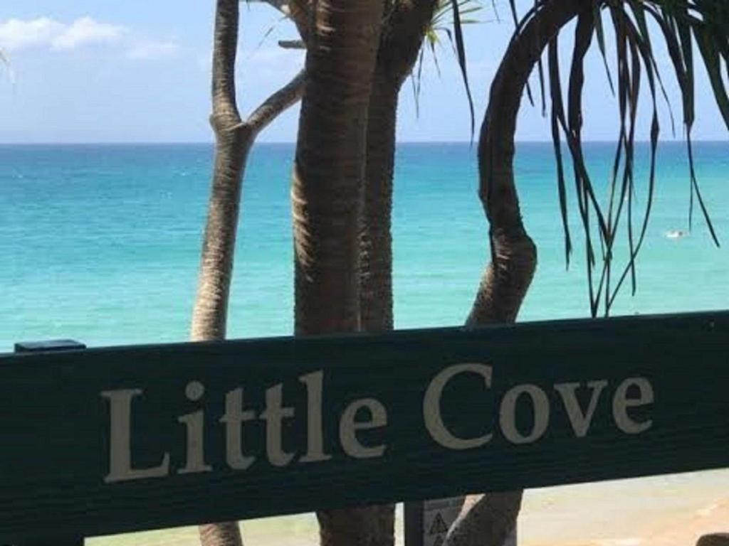 a green sign that reads little cove on the beach at Little Cove Townhouse 2 Pandanus Street 14 in Noosa Heads