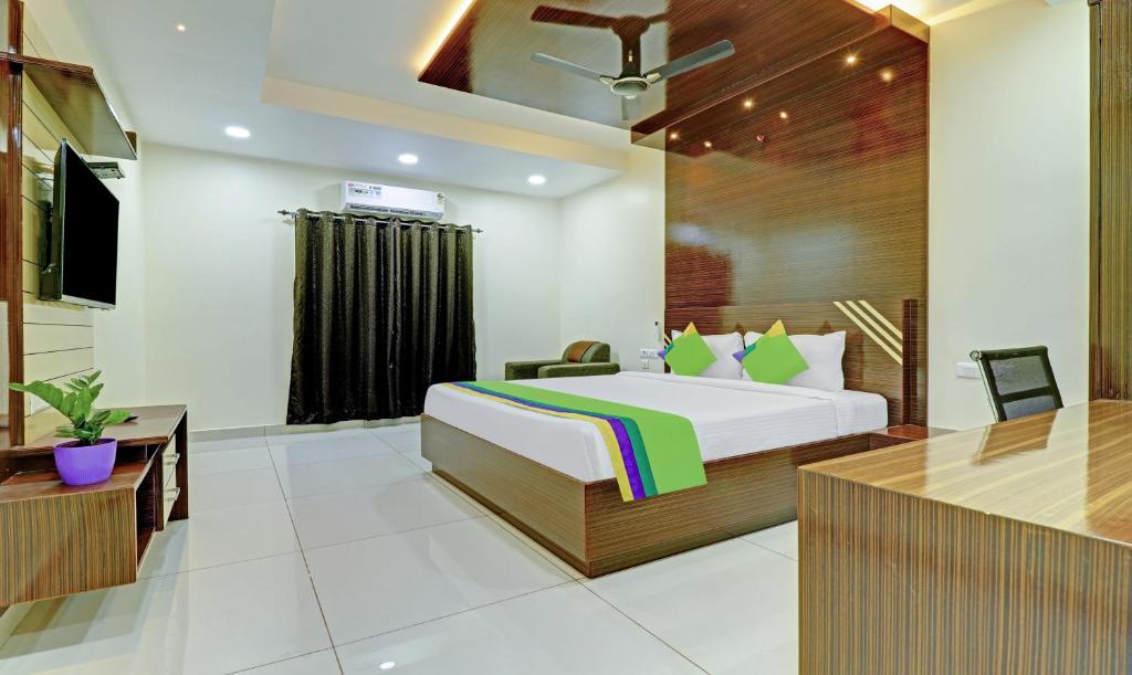 Habitación de hotel con cama y escritorio en Treebo Trend Arka Vijayawada, en Vijayawāda