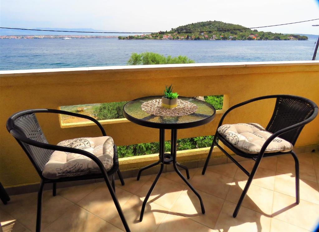 a table and chairs on a balcony with a view of the water at Apartment for 4 persons, by the sea and with beautiful view in Kali