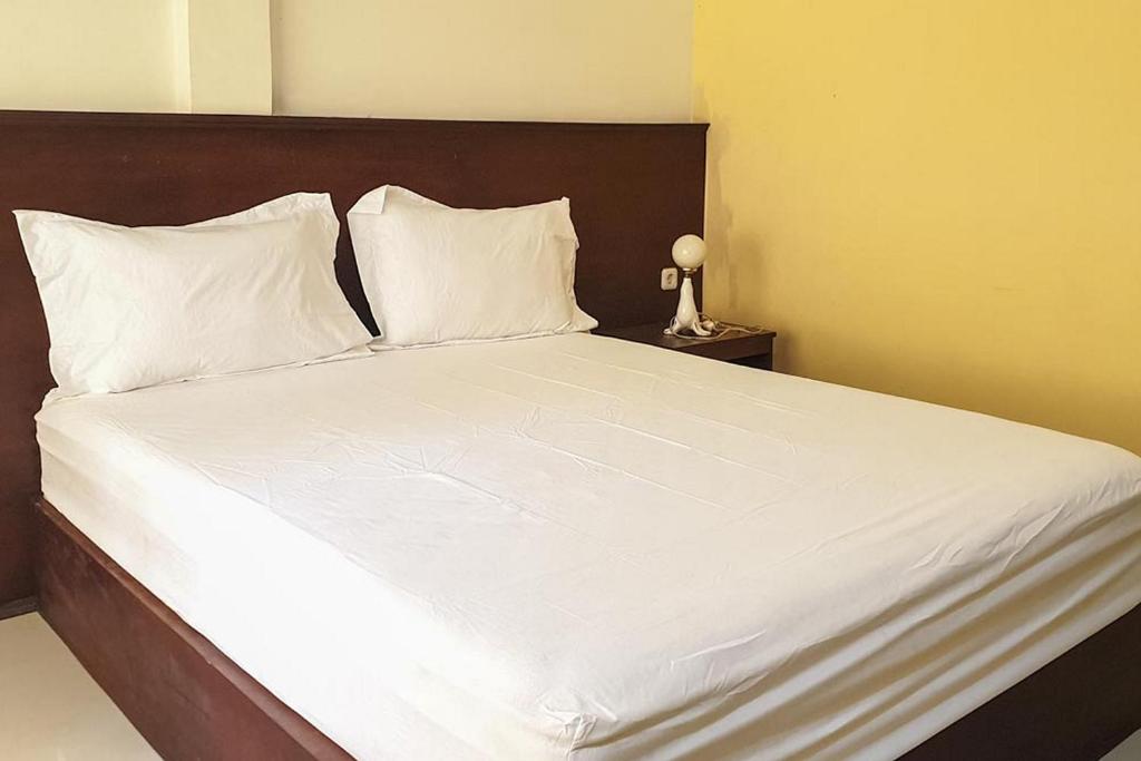 a large white bed with white sheets and pillows at Bromo 22 Homestay Syariah near Terminal Bayuangga Probolinggo Mitra RedDoorz in Pilang