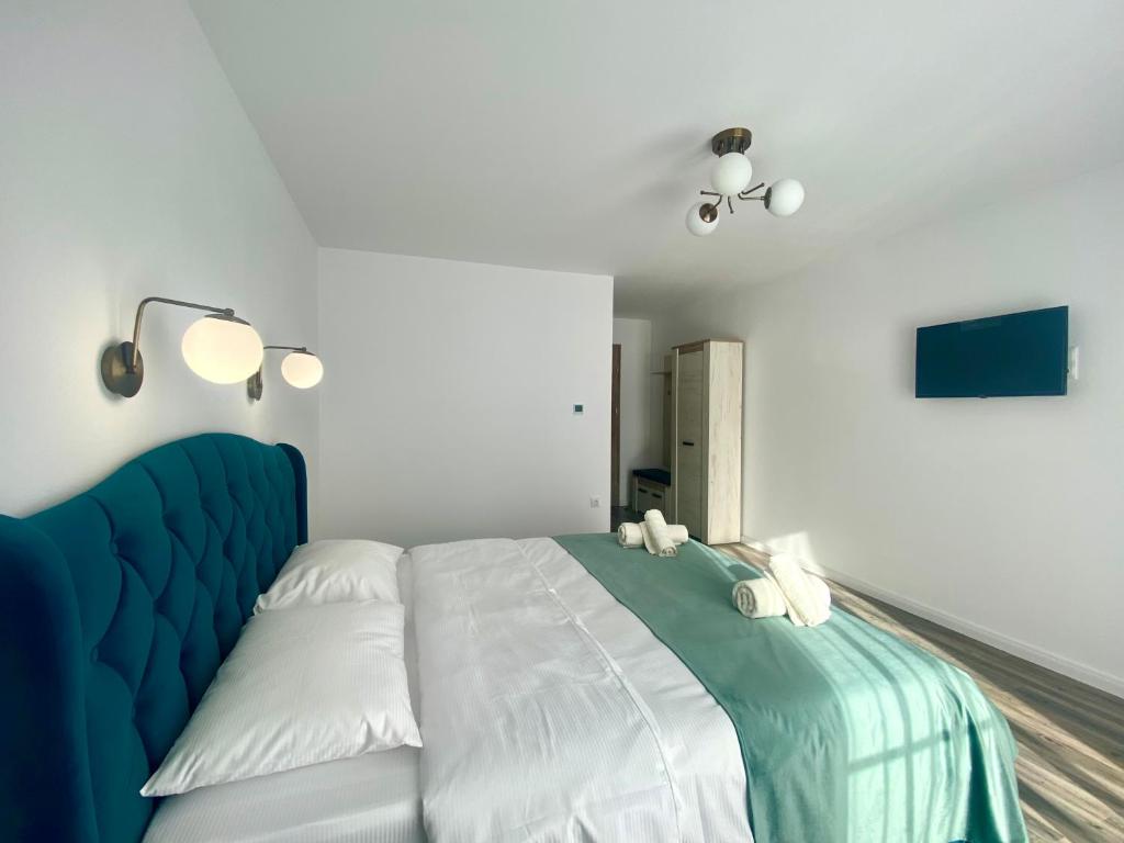 une chambre avec un grand lit et une tête de lit bleue dans l'établissement Alpin House Colibita, à Colibiţa