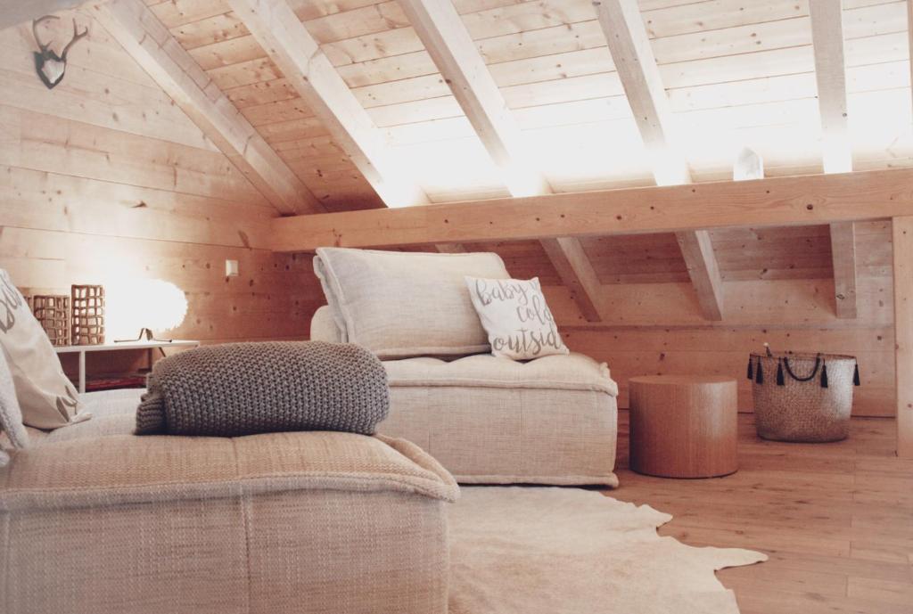 ein Wohnzimmer mit einem Sofa und einem Stuhl in der Unterkunft Lieblingsort - Cosy Black Forest Chalets in Neuenweg