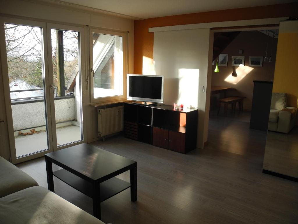 uma sala de estar com um sofá, uma televisão e uma mesa em Apartment Yvonne em Eimeldingen