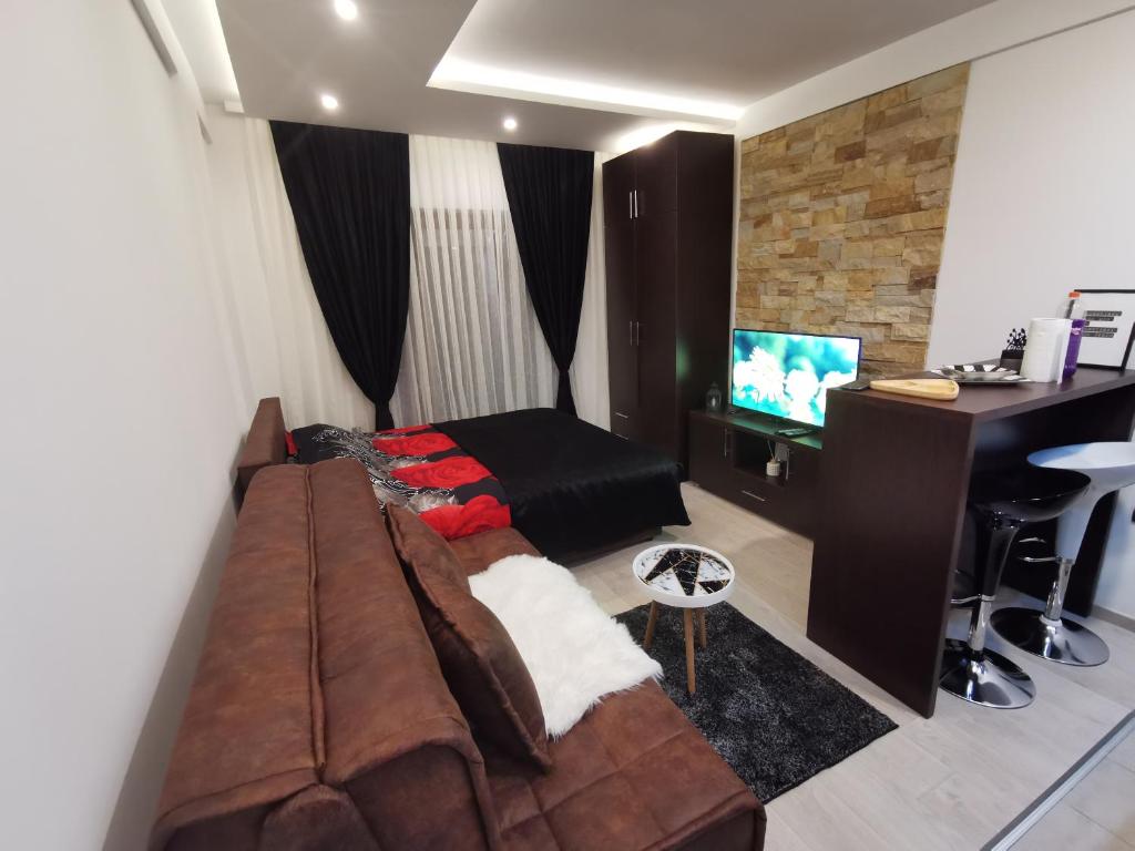 ein Wohnzimmer mit einem Sofa und einem TV in der Unterkunft Kopaonik apartmani NR in Kopaonik