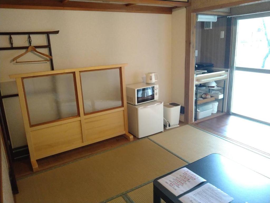 a small kitchen with a refrigerator and a microwave at Tsukechi Bachanchi - Vacation STAY 88747v in Nakatsugawa