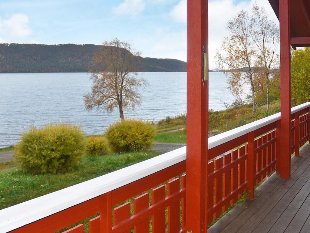 a red porch with a view of a lake at 6 person holiday home in VATNE in Vatne