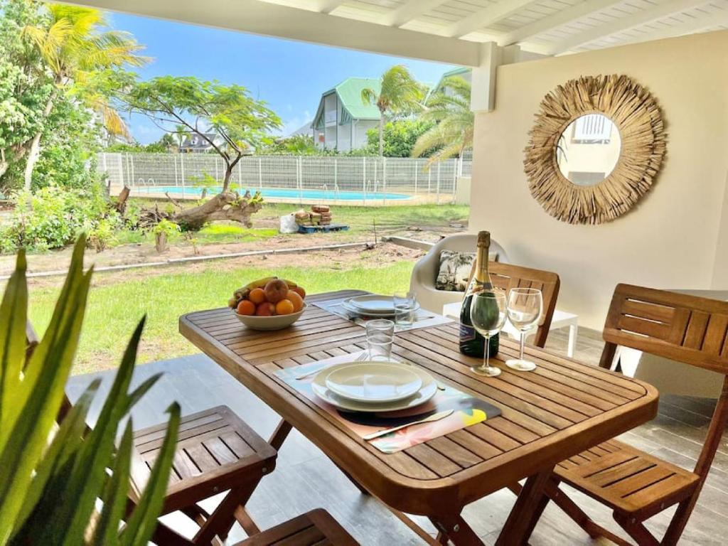 una mesa de madera con un bol de fruta en el patio en Maracuja 6, Orient Bay village, walkable beach at 100m, en Orient Bay