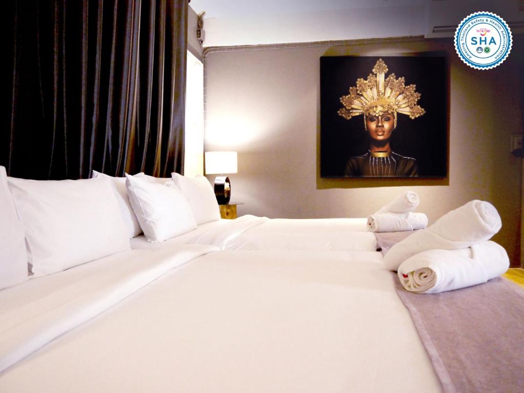 ein Schlafzimmer mit einem großen weißen Bett mit Handtüchern darauf in der Unterkunft Sabaiday Guesthouse Nimman in Chiang Mai