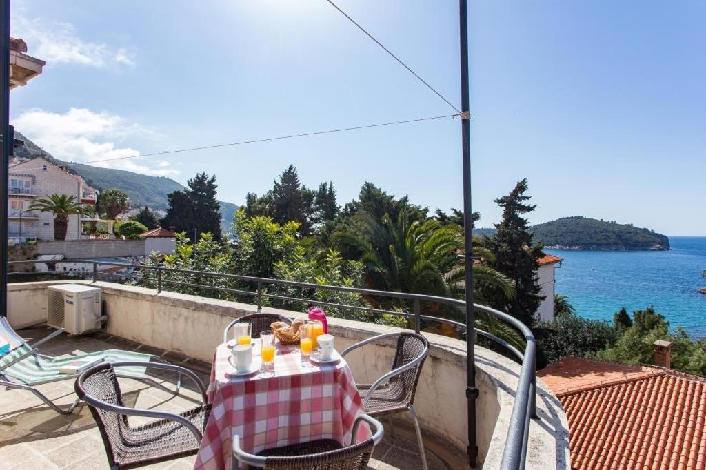 a table on a balcony with a view of the ocean at Holiday Home Patricija in Dubrovnik