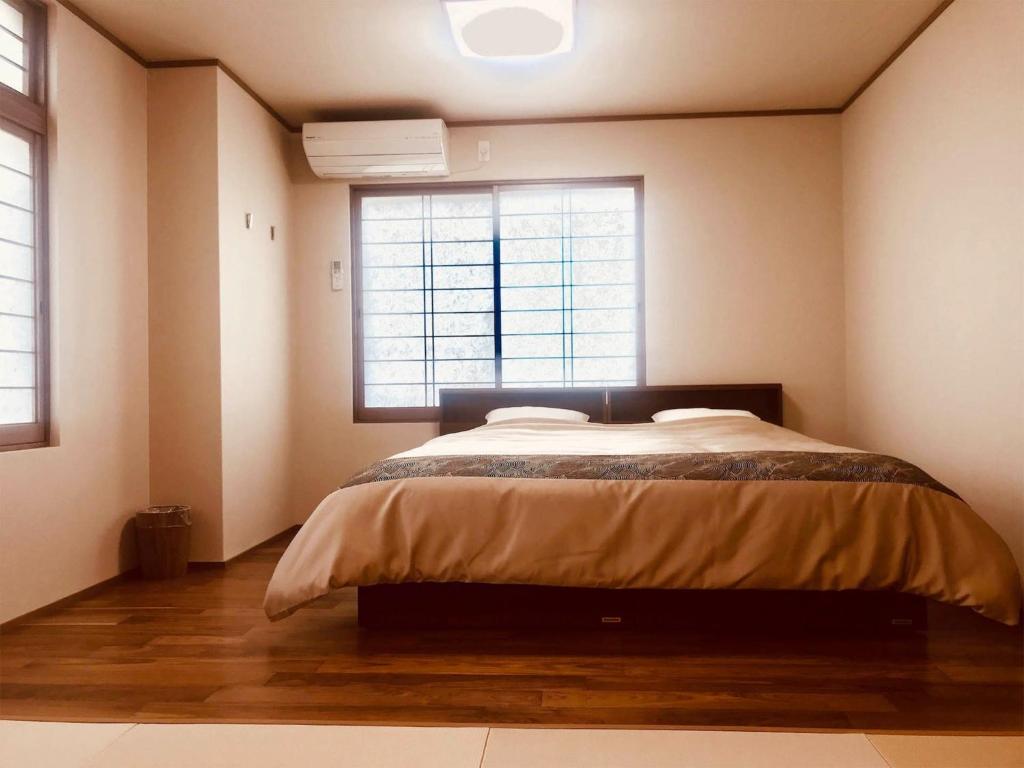 a bedroom with a bed and a large window at Daigo - Vacation STAY 07997v in Kanayama