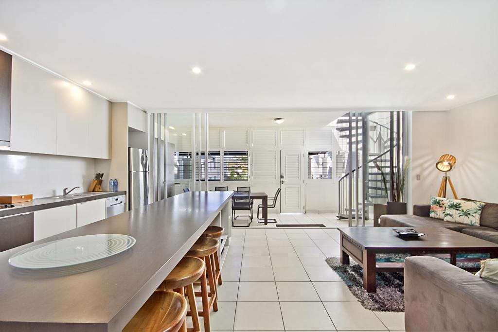 a kitchen and living room with a table and a couch at Spacious 3 bedroom apartment opposite surf club in Kingscliff