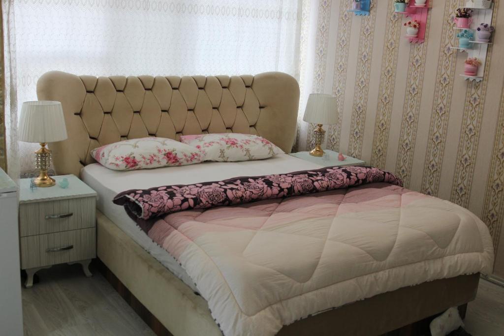 a bedroom with a large bed with two lamps and a window at SAYDAM OTEL in Seyhan