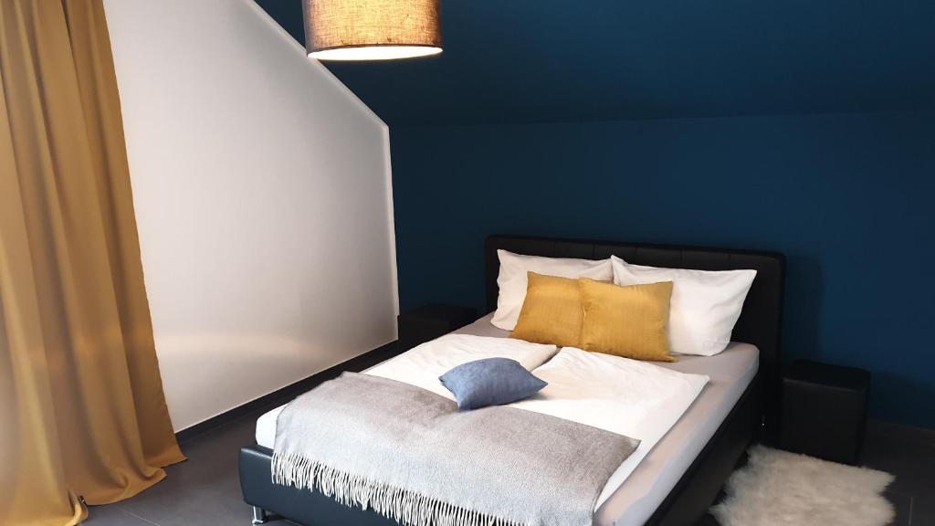 a bedroom with a bed with a blue wall at FeWo Schönfeld in Balingen