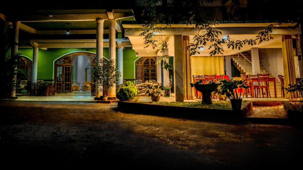 丹布勒的住宿－加馬基德拉度假酒店，绿色建筑,设有门廊,配有桌椅