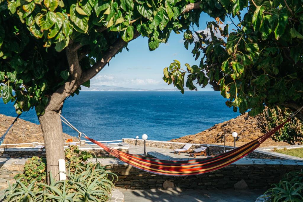 a hammock hanging from a tree next to the ocean at Cape Napos in Faros