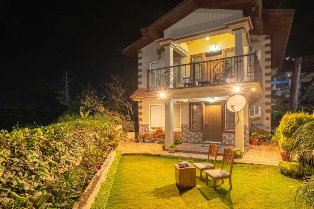 a house with a lawn in front of it at night at StayVista by Harmony Villa - Cosy Abode with contemporary-styled-décor in Bhīm Tāl