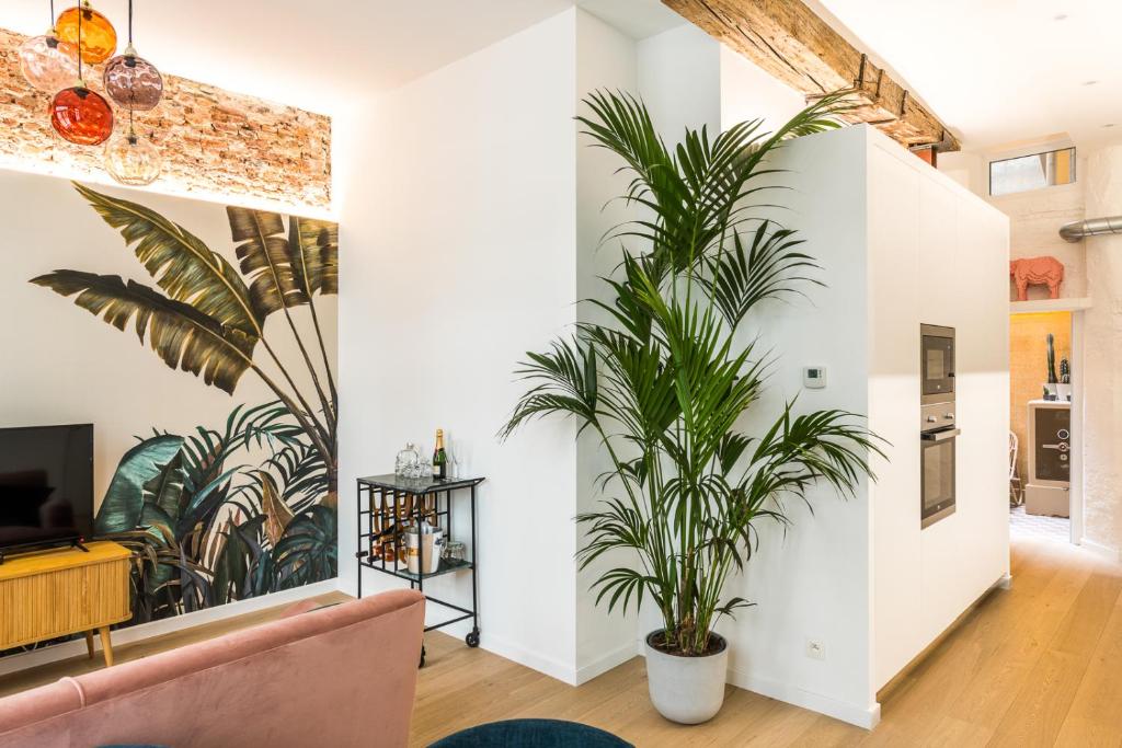 een woonkamer met witte muren en een potplant bij Beautiful appartment in the heart of Antwerp in Antwerpen