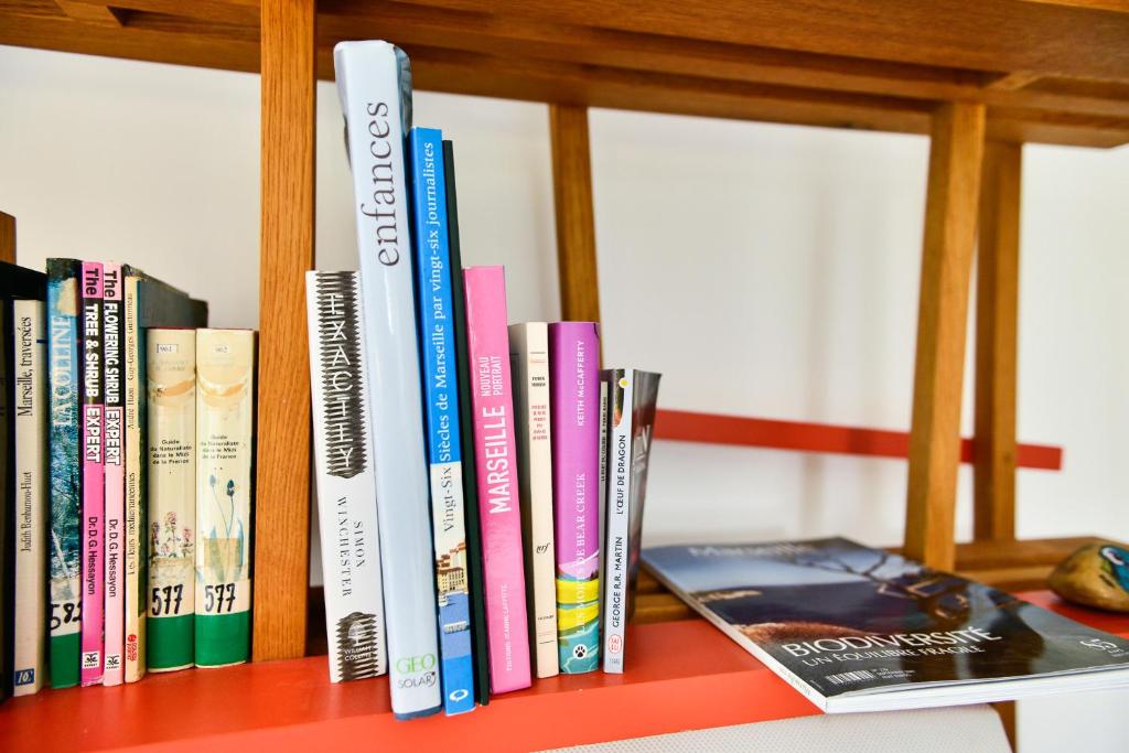a row of books on a book shelf at L’appartement - Jardin Secret in Marseille