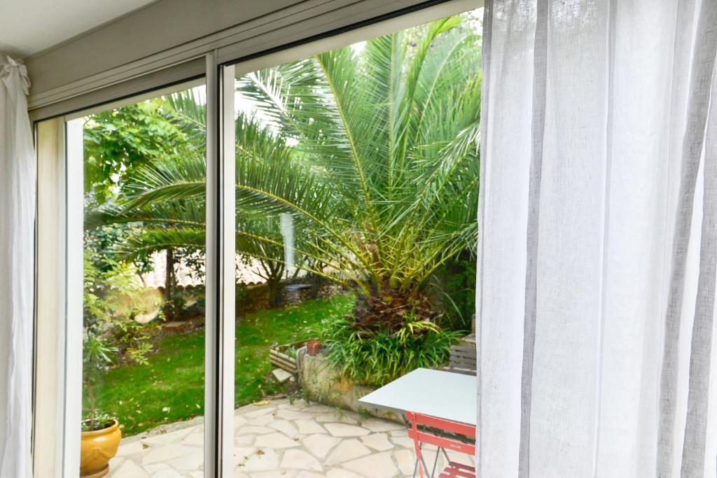 a sliding glass door with a view of a garden at L’appartement - Jardin Secret in Marseille
