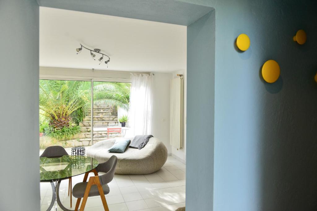 a living room with a table and a couch at L’appartement - Jardin Secret in Marseille