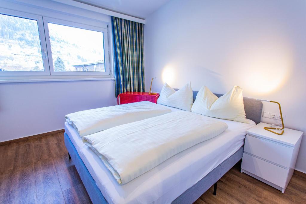 um quarto com uma grande cama branca e uma janela em City Dream 2 by Alpenidyll Apartments em Schladming
