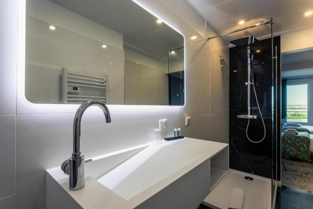 a bathroom with a sink and a mirror at Hôtel Le Mistral in Marseille