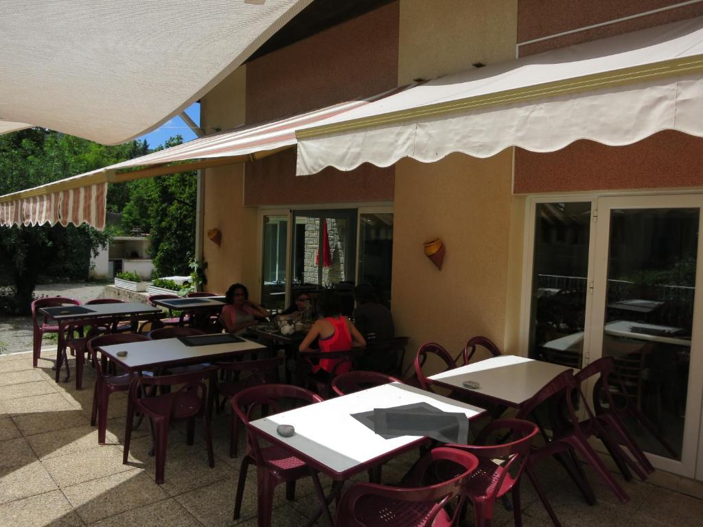 un grupo de mesas y sillas en un restaurante en Le Pidanoux, en Saint-Julien-du-Verdon