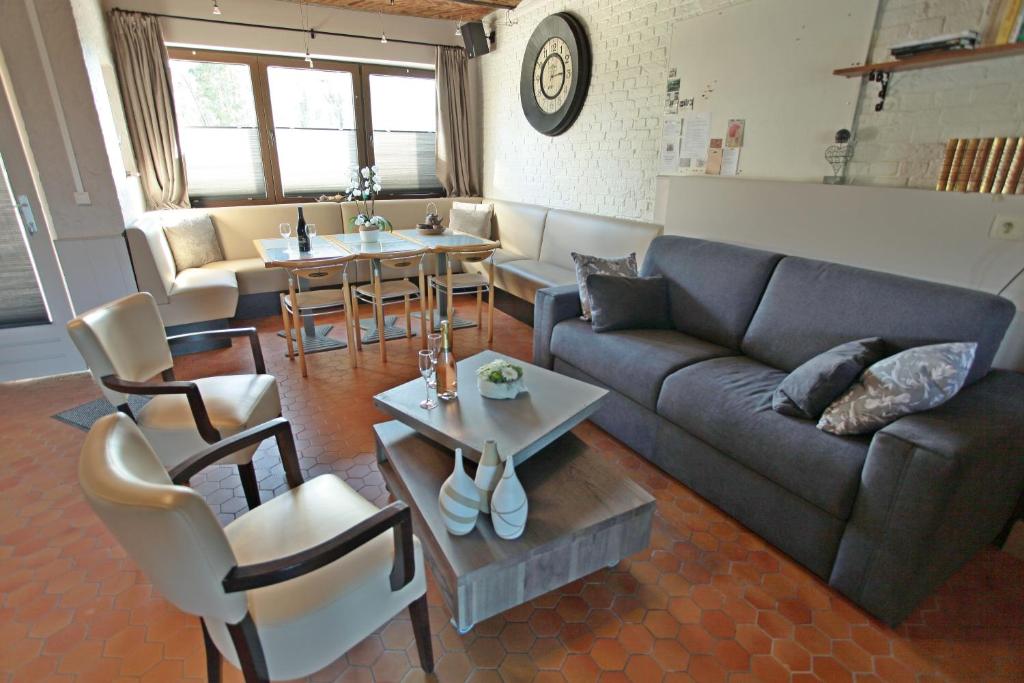 ein Wohnzimmer mit einem Sofa, einem Tisch und Stühlen in der Unterkunft Le Moulin de Nancy in Hour