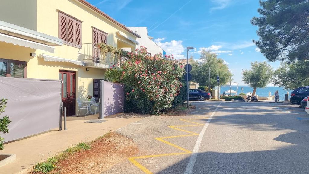een straat met een gebouw en de oceaan op de achtergrond bij Room Fiore in Novigrad Istria
