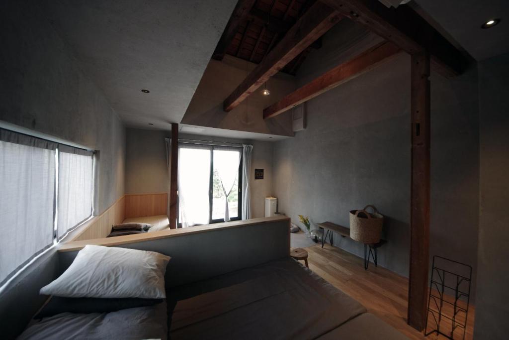 1 dormitorio con cama y ventana grande en -1日1組限定-犬と泊まれる古民家宿 wanco minca わんこみんか en Minamiawaji