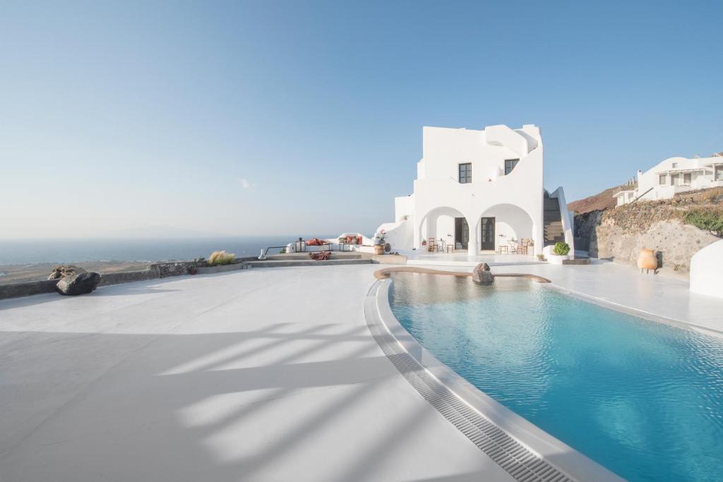 een zwembad met een wit gebouw en de oceaan bij Sophia Boutique Hotel in Oia