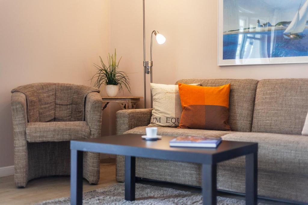 a living room with a couch and a table and a chair at Seebach Wohnung 18 in Boltenhagen