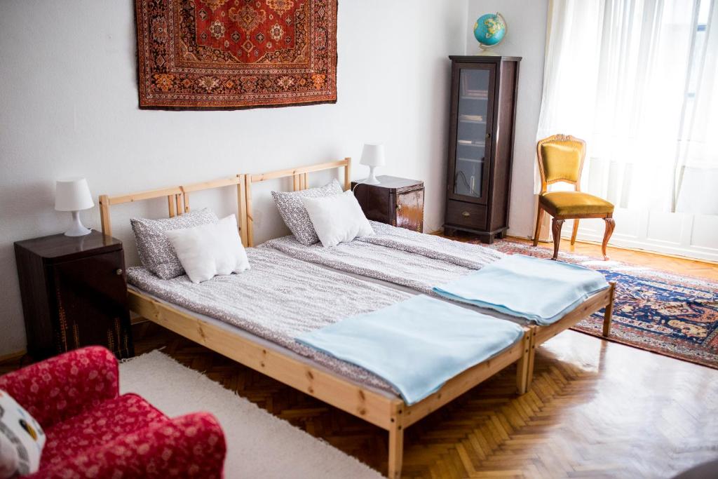 ブダペストにあるSipi Apartmanのベッドルーム1室(ベッド1台、椅子1脚付)