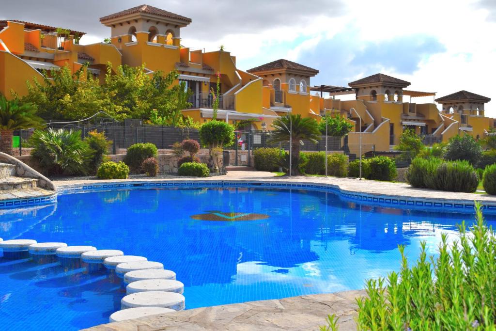 una piscina frente a un edificio en Apartamento con hermoso jardín y AC, en Isla Plana