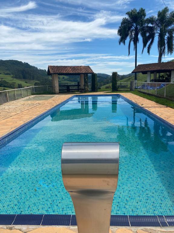 a large swimming pool with blue water at Fazenda Mantiqueira e Restaurante in Camanducaia