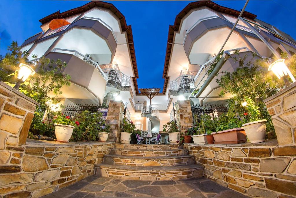 a stone building with stairs and potted plants at Sky Hotel in Sarti