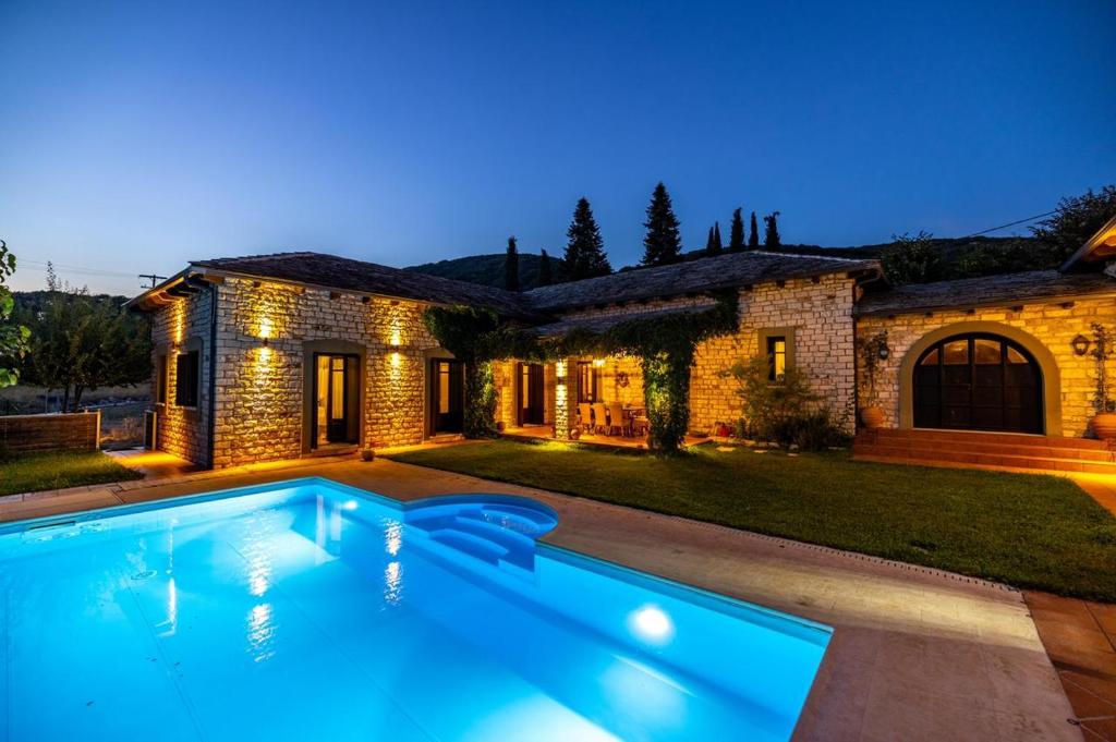 a swimming pool in front of a house at Patriko Estate in Epirus in Térovon