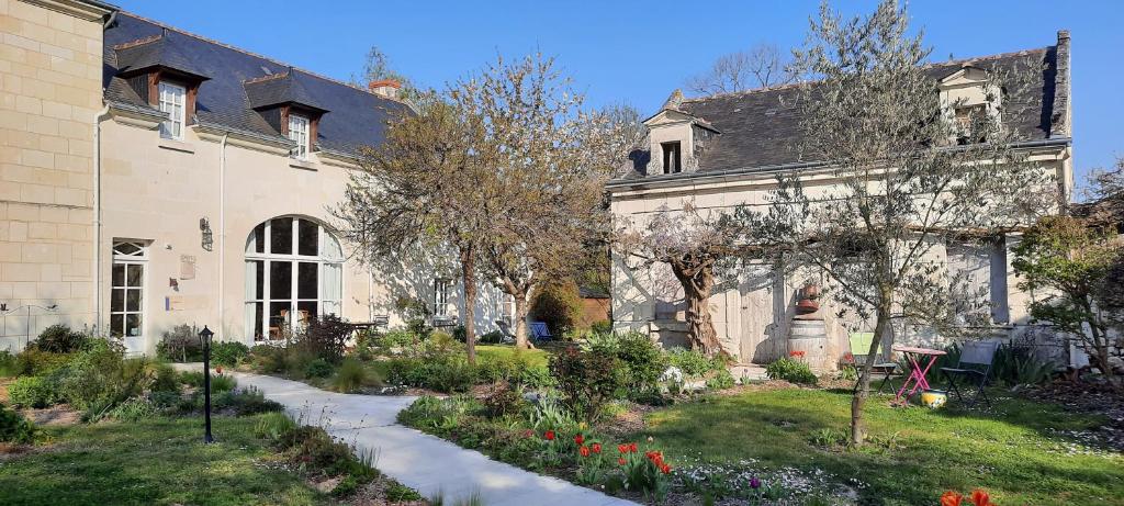 uma casa antiga com um jardim em frente em La Magnanerie em Savigny-en-véron