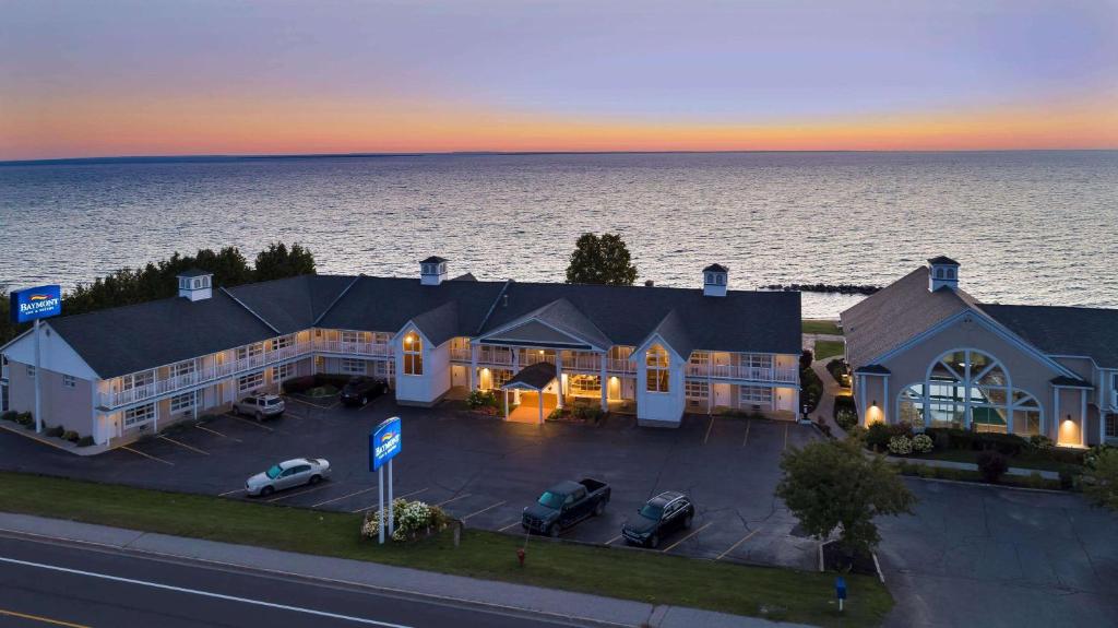 an aerial view of a hotel with a parking lot at Baymont by Wyndham St. Ignace Lakefront in Saint Ignace