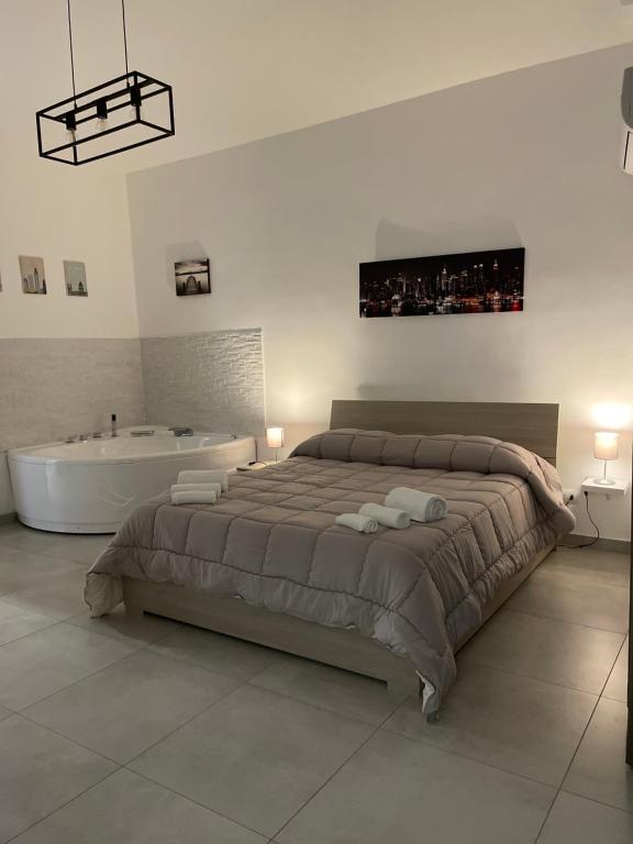 a bedroom with a large bed and a bath tub at Rosa Dei Venti Apartment in Catania