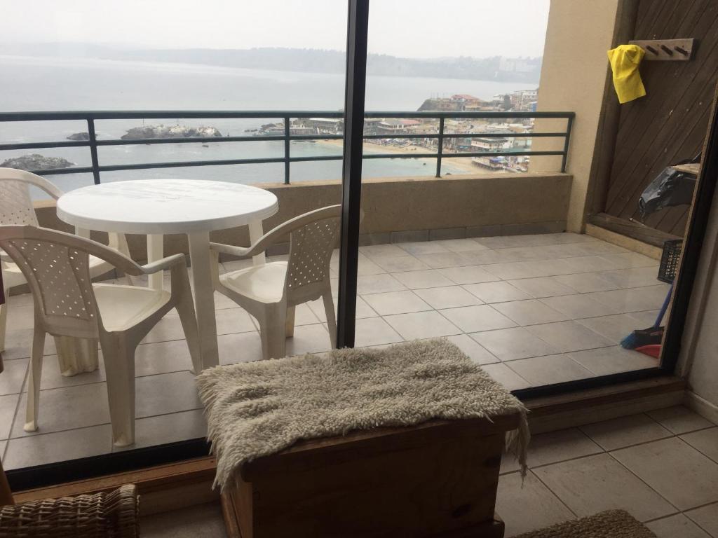 a balcony with a table and chairs and a view of the ocean at Horcon Condominio CAUCAU in Horcón