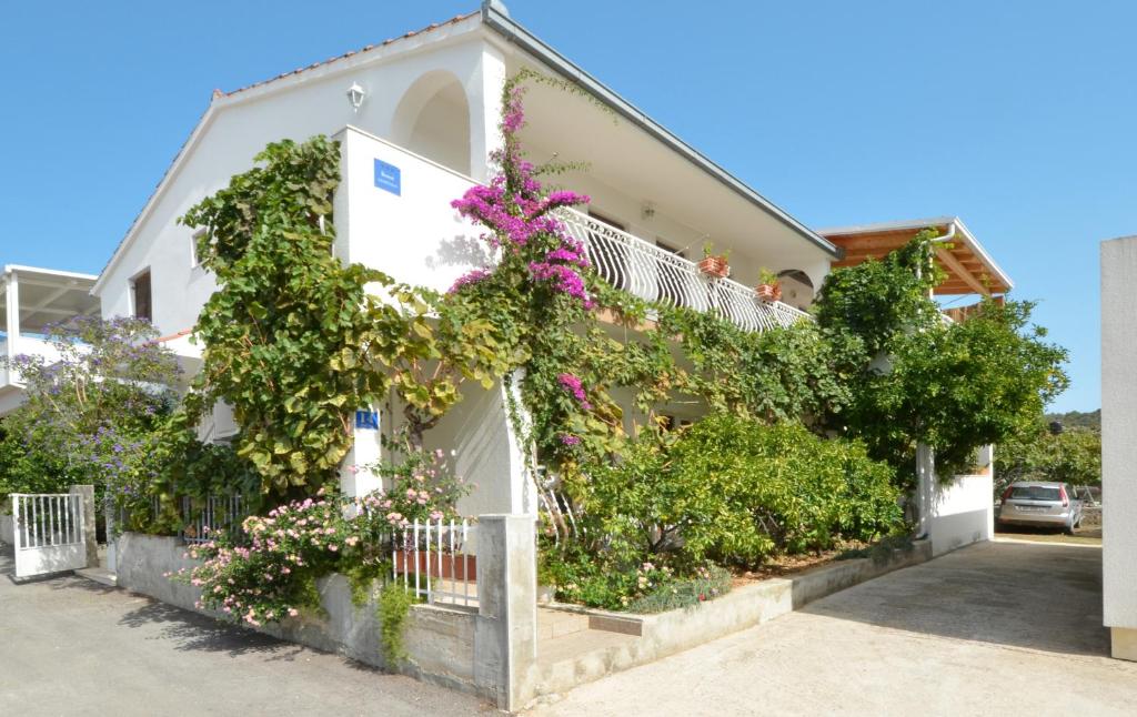 una casa con flores a un lado. en Apartments Nina, en Vinišće