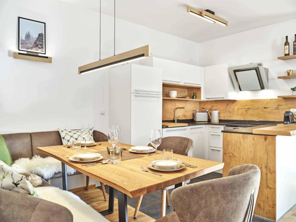 a kitchen and dining room with a wooden table and chairs at Sunlodge Oeblarn Top C3 Schladming-Dachstein in Öblarn