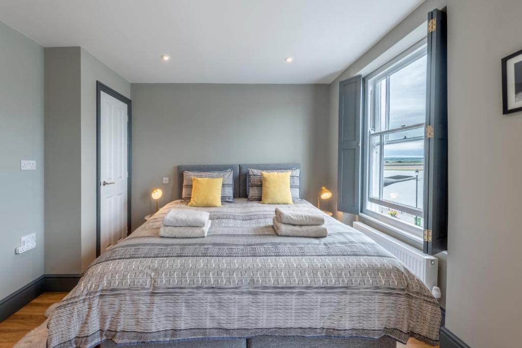 een slaapkamer met een groot bed met gele kussens bij Sailors Rest in Appledore