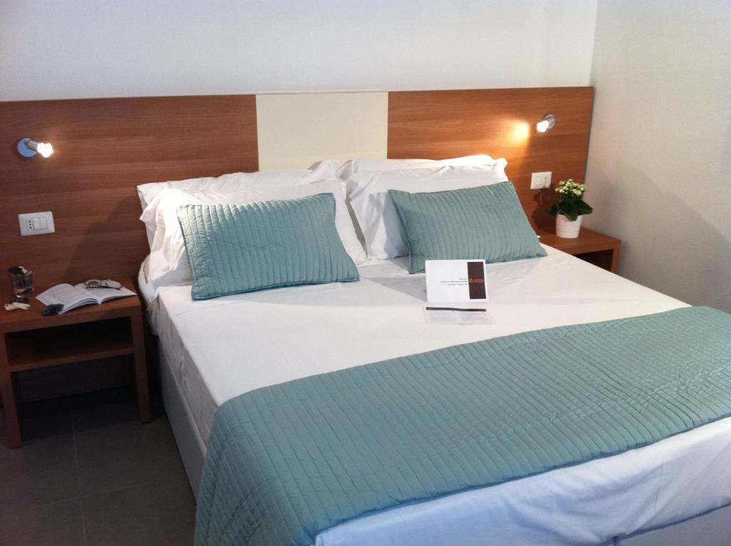 - une chambre avec un grand lit blanc et des oreillers bleus dans l'établissement Holidays S.Lorenzo Guest House New, à Rome
