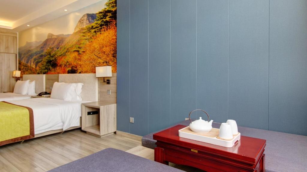 a bedroom with a bed and a painting on the wall at Vyluk Hotel Yuncheng Salt Lake Nanfeng Plaza in Yuncheng