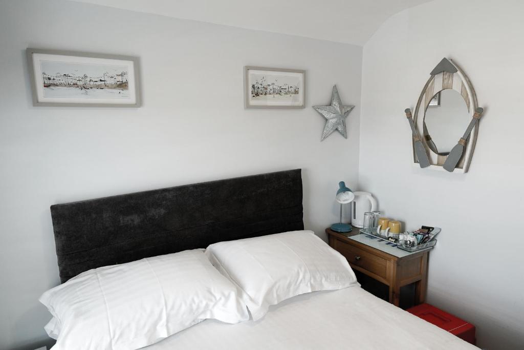 a bedroom with a bed and a table with a mirror at Southville Guest House in Weymouth