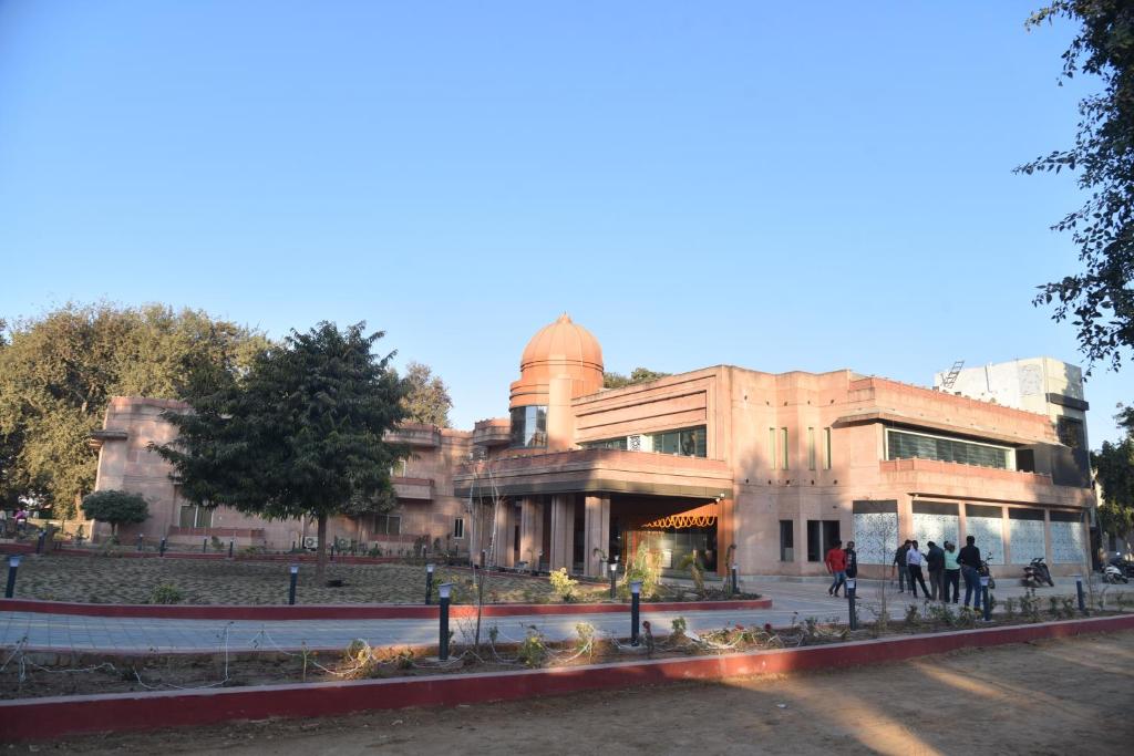 a building with people walking in front of it at The River Front Resort in Sītāpur Mūāfi