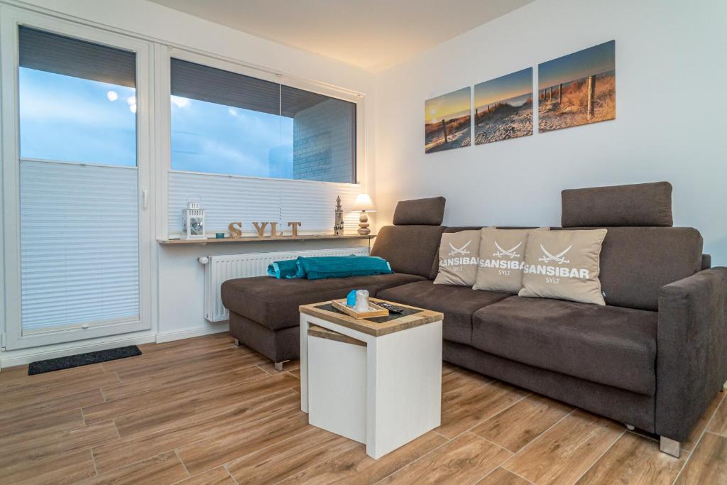 ein Wohnzimmer mit einem Sofa und einem Tisch in der Unterkunft Sylter Perle in Westerland