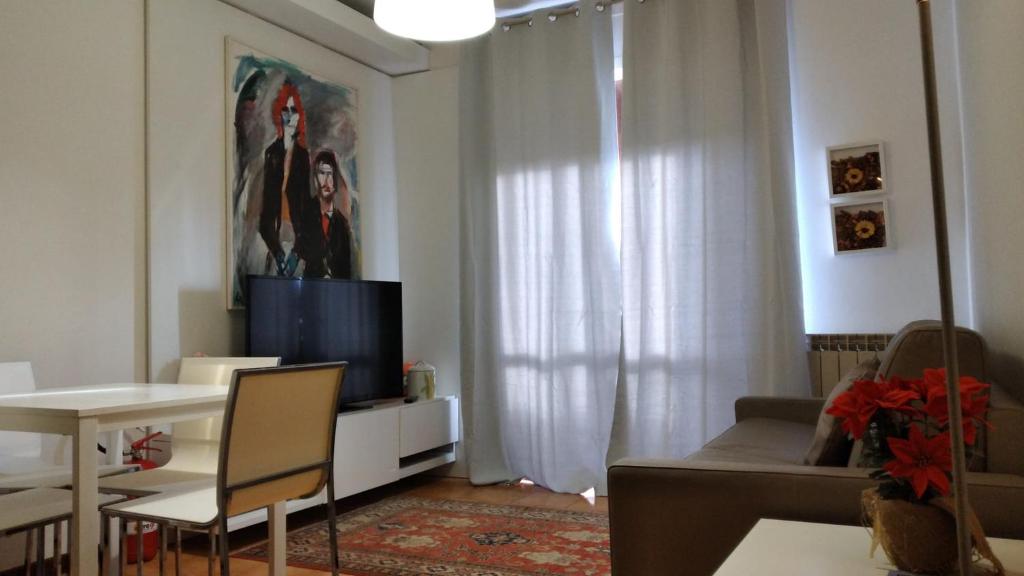 sala de estar con sofá, mesa y TV en Casa Carducci, en Turate